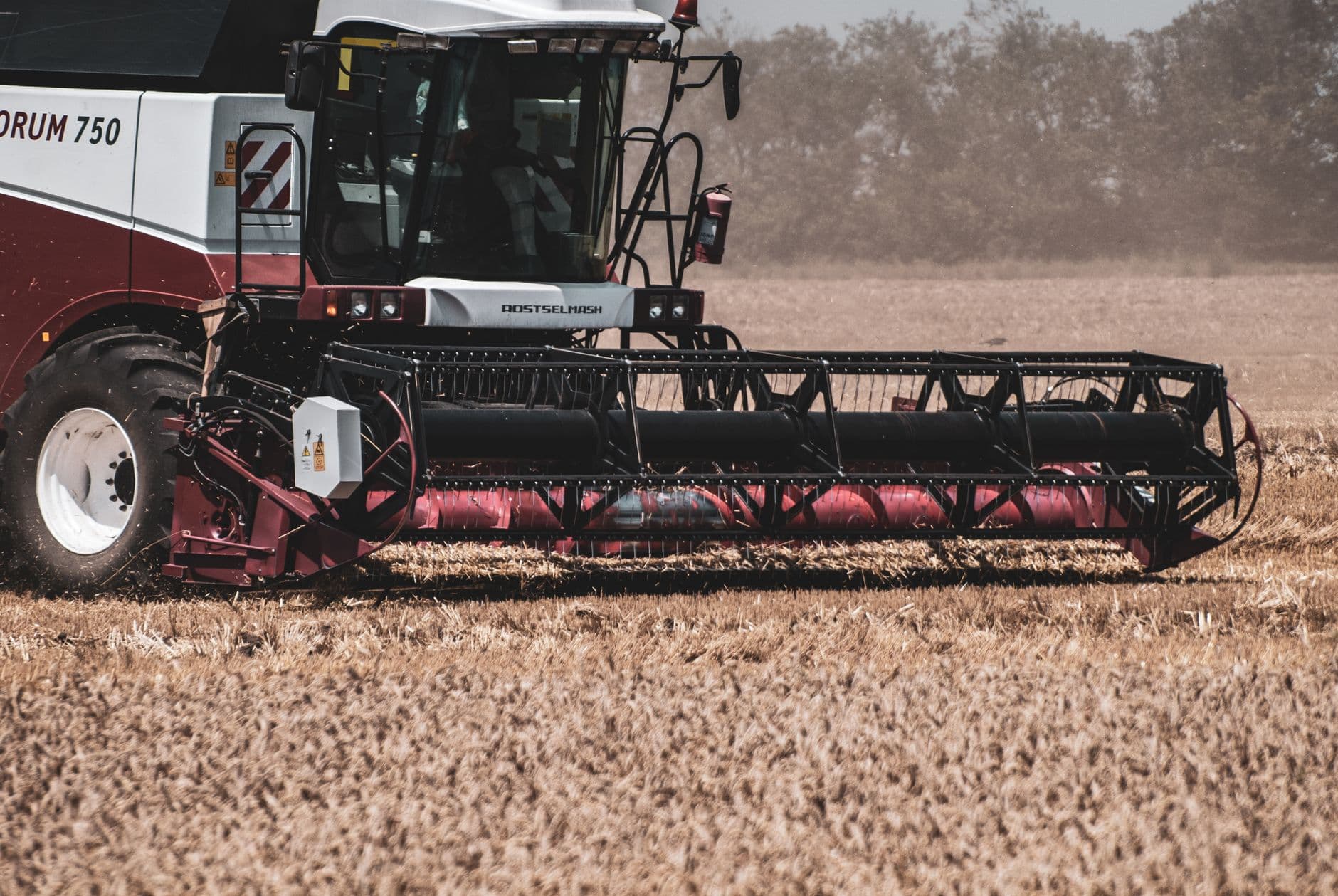 Combine harvester working in a wheat field during daytime, showcasing modern agricultural machinery.